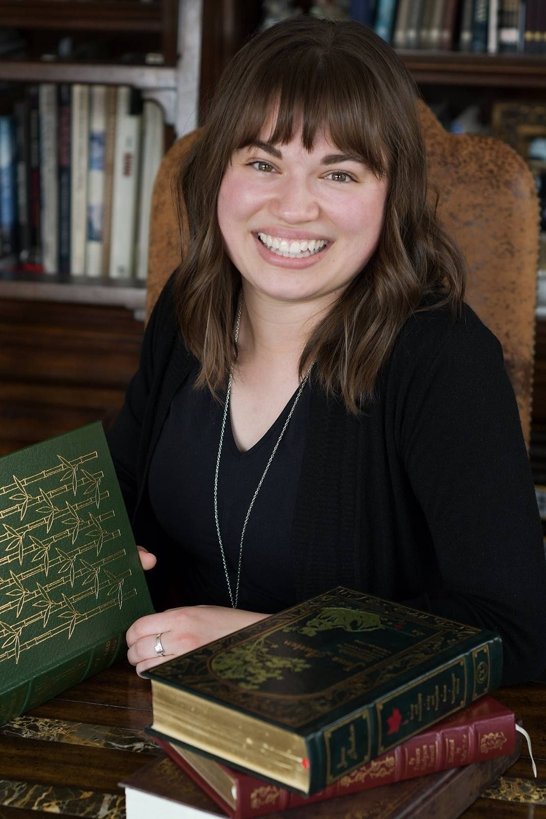 Maren Sommer smiling in front of a book case.